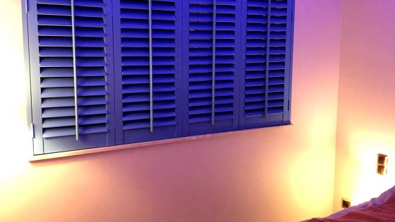 niebieskie shuttersy w sypialni z podświetleniem
